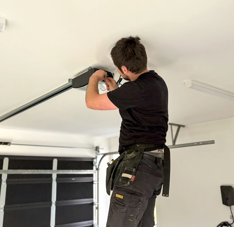 Garage door technician working on opener system inside Denver Colorado garage
